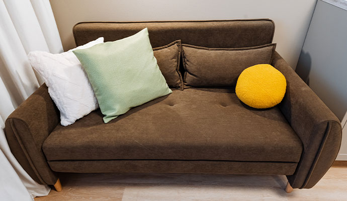 Clean brown couch with colorful throw pillows
