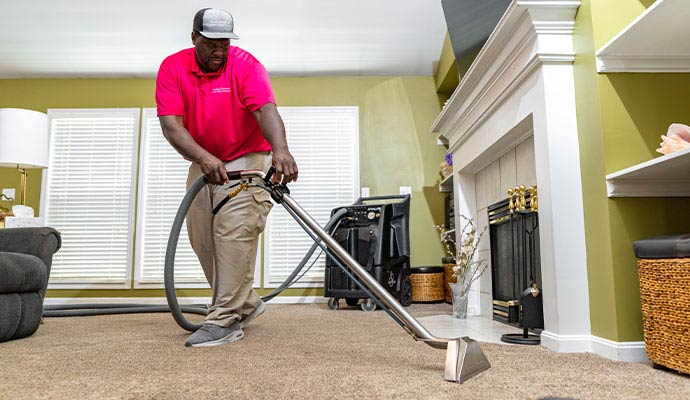 Experienced worker cleaning carpet using equipment