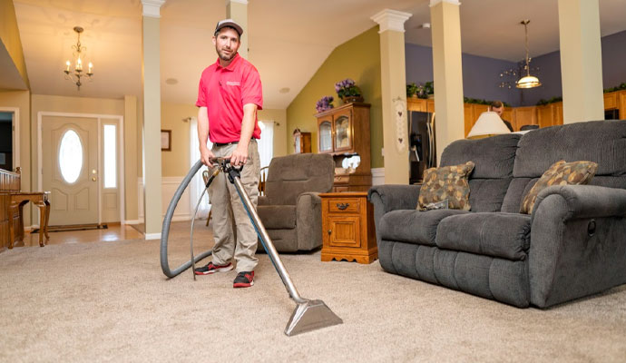 Professional technician dry cleaning a living room carpet