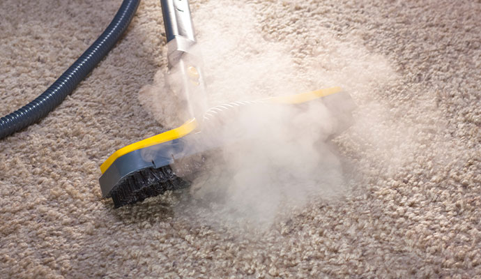 Steam cleaning brush nozzle cleaning carpet with hot steam.
