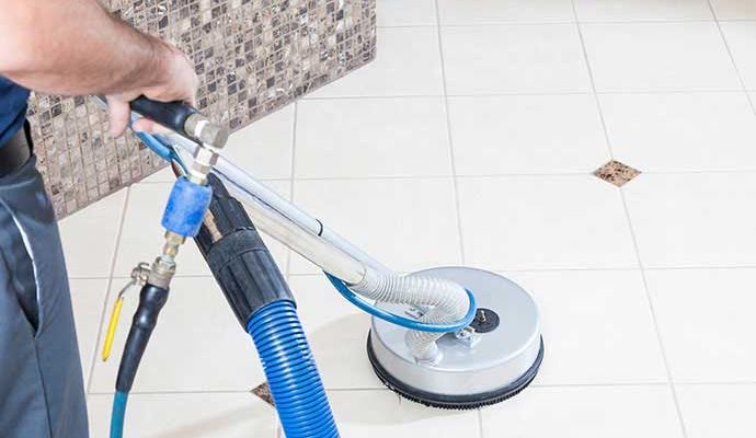 Professional tile and grout cleaning in a commercial space using specialized equipment