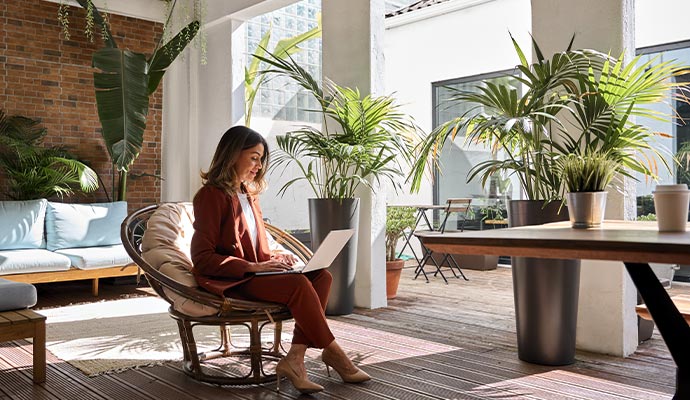 Women sitting on chair working with laptop in clean commercial space