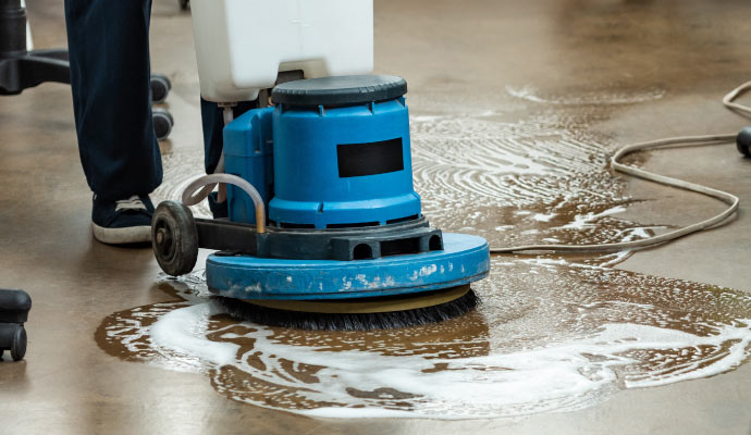 Professional worker cleaning concrete floor