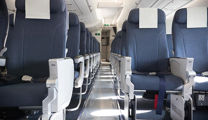 Empty airplane cabin with rows of blue seats