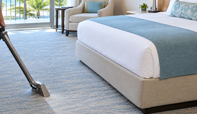 An expert cleaning carpet in a hotel room