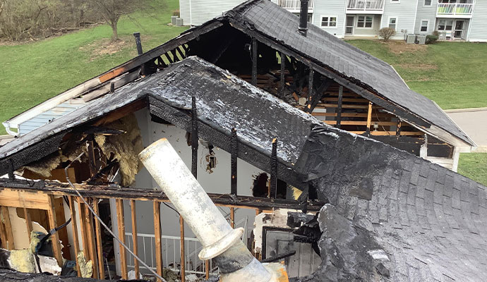 Burned-out residential roof with destroyed structural framing.