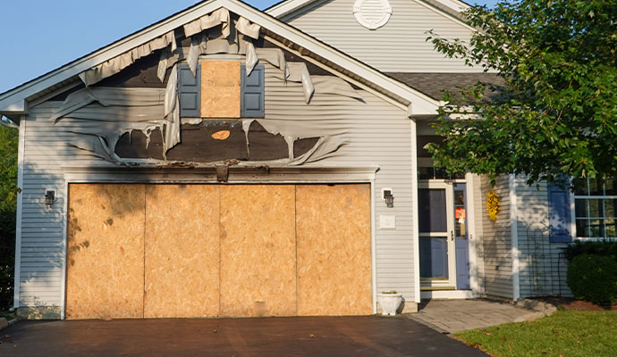 Fire-damaged house secured with plywood board-up service.