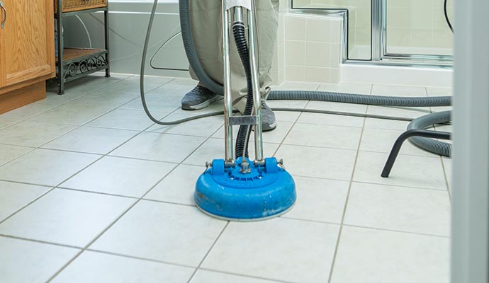 Cleaning tile floor and grout lines using equipment