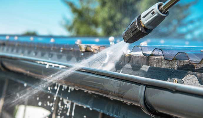 Professional worker cleaning gutter