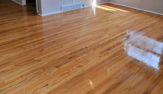 Shiny and clean laminate wood flooring in a residential living space reflecting natural light