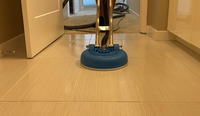 Professional worker cleaning tile