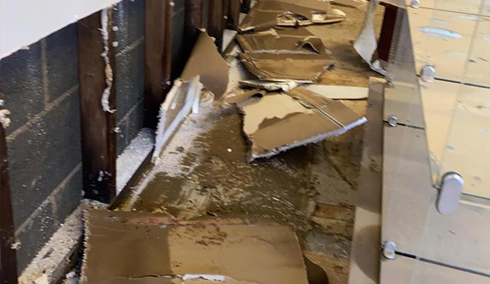Damaged interior wall with exposed debris
