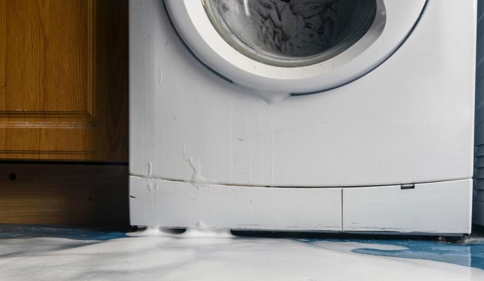 Close up view of a washing machine leaking water.