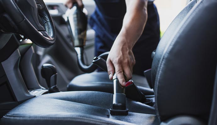 Expert performing a professional auto cleaning service inside a car