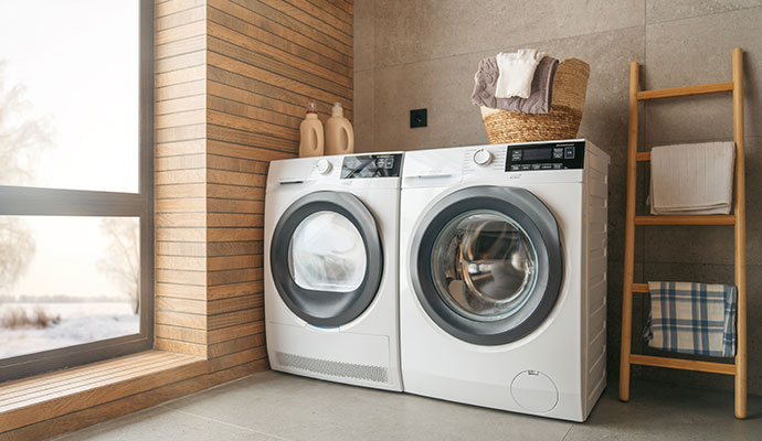 Modern washing machine and dryer in a laundry room.