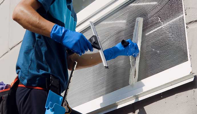 Professional worker cleaning window