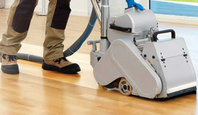 Professional worker cleaning wood floor